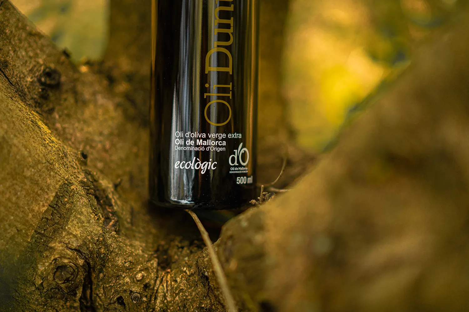 Botella d'oli ecològic damunt arbre
